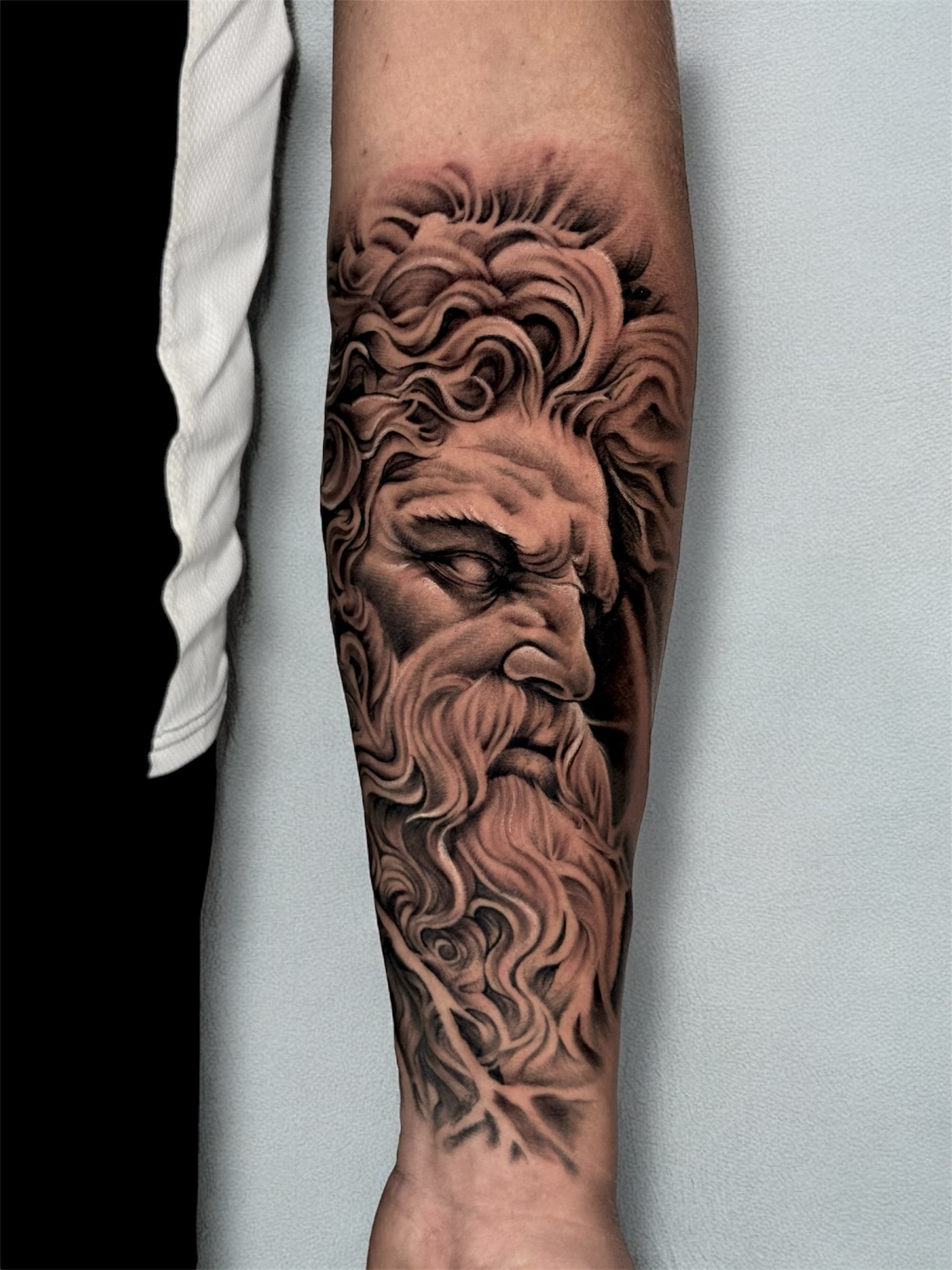 Realistic Greek god inner forearm tattoo